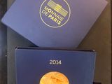 la boîte est ouverte sur un plateau dans lequel se trouve une pièce d'or
