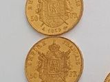 four gold coins are arranged in a row on a white surface