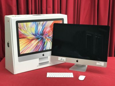 un écran d'ordinateur et un clavier posés sur une table rouge