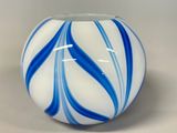 a blue and white striped vase on a table