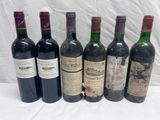 six bottles of wine are lined up on a table