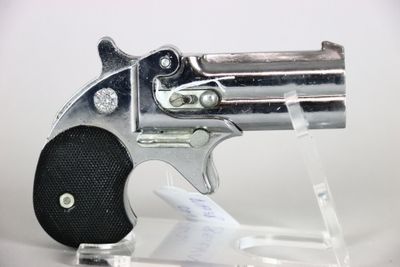 a silver revolver with a black grip on a clear stand