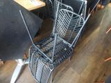 a metal chair that has a basket on the back of it