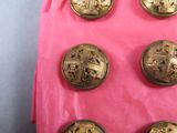 several gold buttons on a pink surface with a pink background