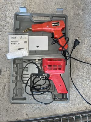 a red corded gun and some wires in a case