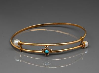 a close up of a gold bracelet with pearls and a turquoise stone