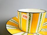une tasse et une soucoupe jaunes et blanches posées sur une soucoupe