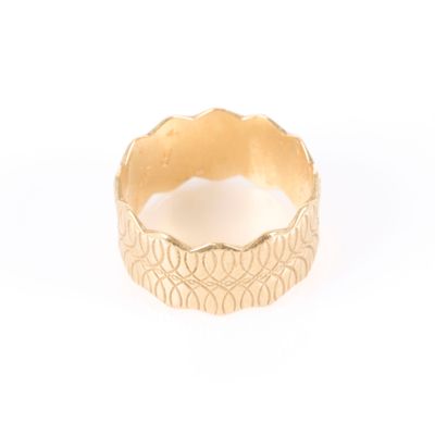 une image représentant une bague en or posée sur une surface blanche