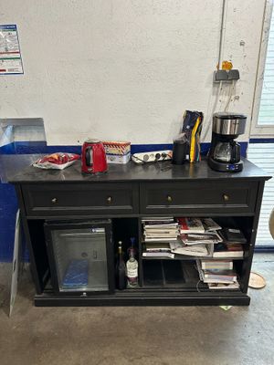 a black cabinet with a coffee maker on top of it
