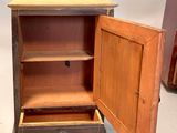a small wooden cabinet with a drawer inside of it