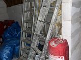 une échelle appuyée contre un mur, à côté d'une borne d'incendie
