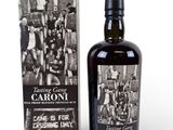 a bottle of caroni with a box of cigarettes next to it