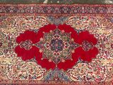 a close up of a red rug with a medallion design