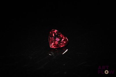 a heart shaped pink diamond on a black surface