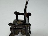 a miniature chair that is sitting on a white surface