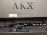 un fusil AKX dans une boîte posée sur un lit
