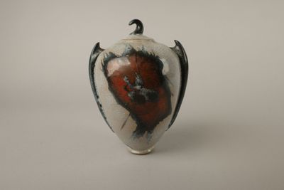un vase blanc orné d'un motif rouge et noir