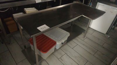 a kitchen with a table and a refrigerator in it