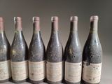 six bottles of wine are lined up in a row on a table