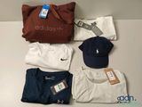beaucoup de t-shirts, de casquettes et un sac posés sur une table
