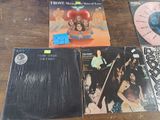 four different vinyl records on a wooden table