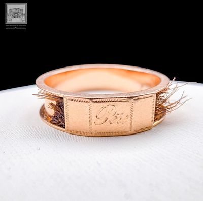 an image of a gold ring on a white surface