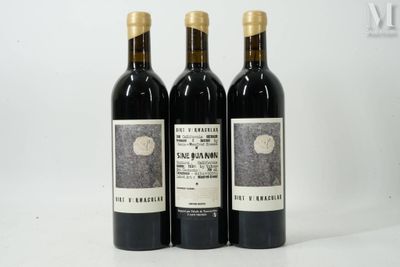 three bottles of wine sitting on top of a white table