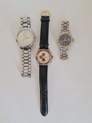 trois montres sont posées les unes à côté des autres sur une surface blanche