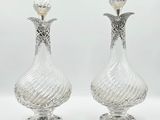 une paire de vases anciens en cristal taillé, posés sur des socles, sur fond blanc