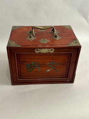 a small wooden box with writing on it on a white background