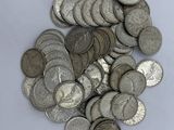 a pile of silver coins sitting on a white surface