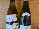 two bottles of wine that are sitting on a shelf