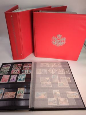 an open red book with stamps on it sitting on top of a table