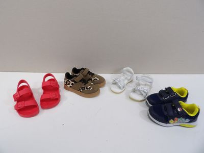trois paires de chaussures de bébé posées sur une table blanche