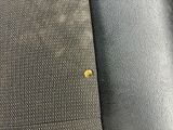 a close up of a tie with a yellow button on it