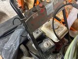 une photo d'un homme utilisant un nettoyeur haute pression dans un garage