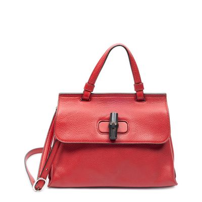 un sac à main en cuir rouge muni d'un fermoir métallique sur la poignée