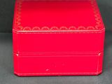 an old red box sitting on top of a gray surface