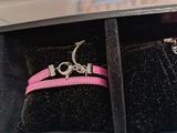 a pink ring in a black box with a pink ribbon