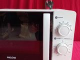 a white microwave oven sitting on a pink cloth
