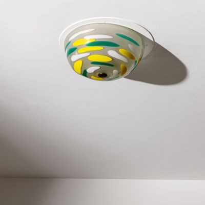 un plafond blanc sur lequel brille une lumière jaune et verte