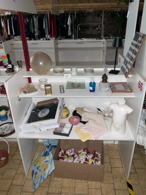 une étagère blanche sur laquelle sont posés divers objets, dans une pièce