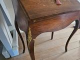 une petite table en bois sur laquelle est posée une horloge
