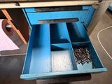 a blue drawer that has a bunch of screws in it