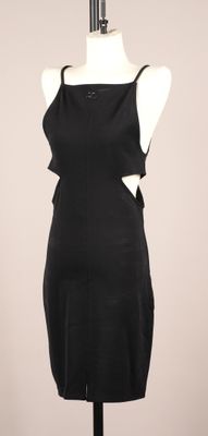 une robe noire exposée sur un mannequin placé sur un socle