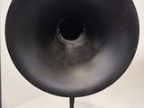 a large black speaker on a stand on a white table
