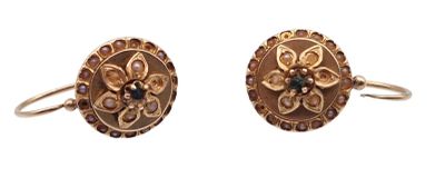 une paire de boucles d'oreilles dorées ornées de pierres bleues et blanches