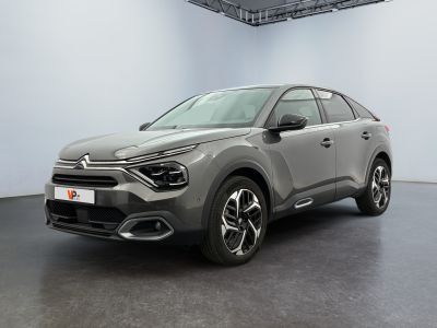 a grey car is parked in a large room with a black floor