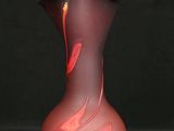 un vase en verre rouge orné d'un tourbillon rouge