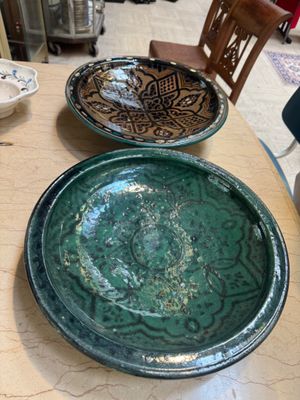 two plates sitting on a table with a chair in the background
